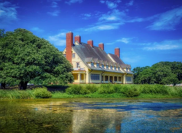 Coastal summer landscape at Whalehead Club in Corolla, NC, with native grasses, oaks, and water views